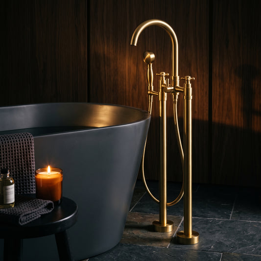 Unlacquered brass tub filler with hand shower beside a dark freestanding bathtub against wood-paneled walls
