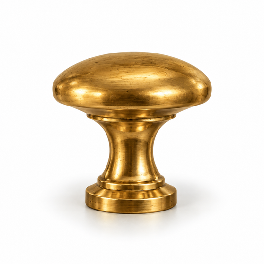 Unlacquered brass cabinet knob with a rounded mushroom-shaped top, antique golden finish, and classic pedestal base.