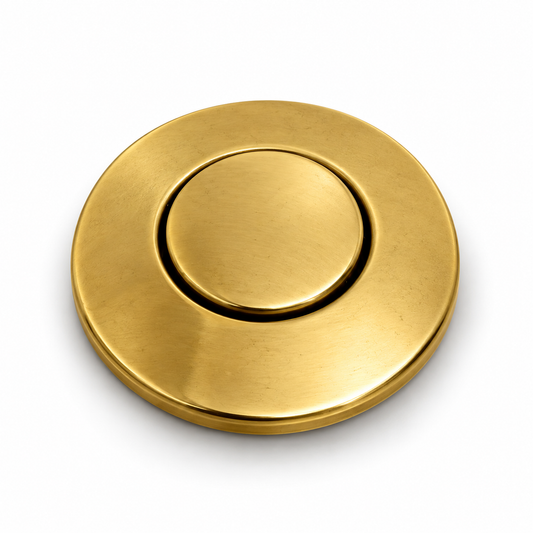 Unlacquered brass garbage disposal air switch button with round escutcheon, angled view on white