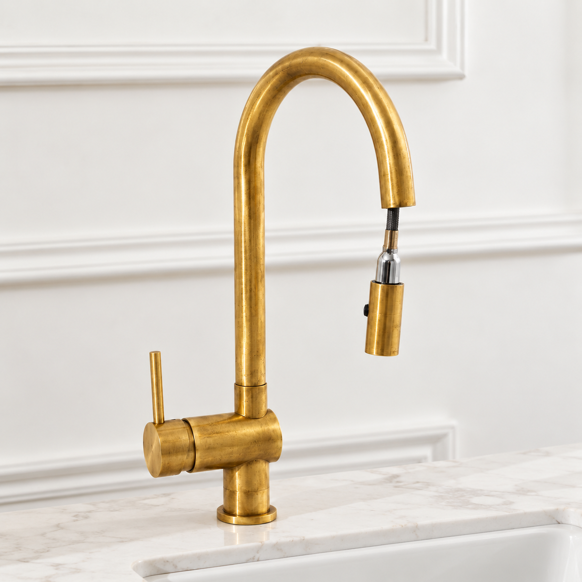 High-arc Brewster brass faucet with pull-down sprayer above a white kitchen sink