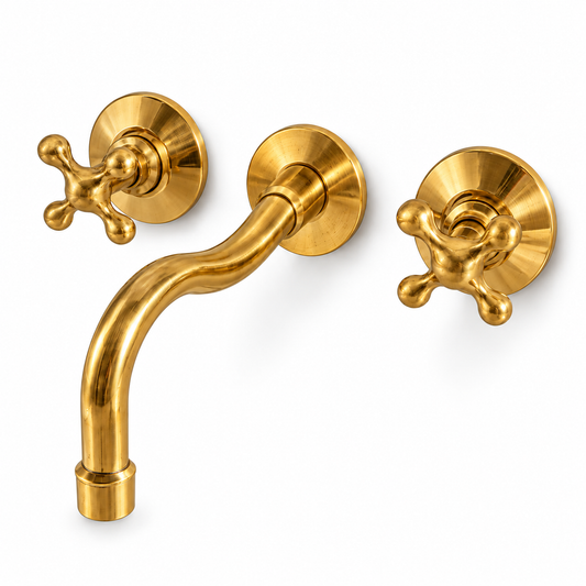 Unlacquered brass wall-mount bathroom faucet with curved spout, rounded cross handles and round wall plates on white