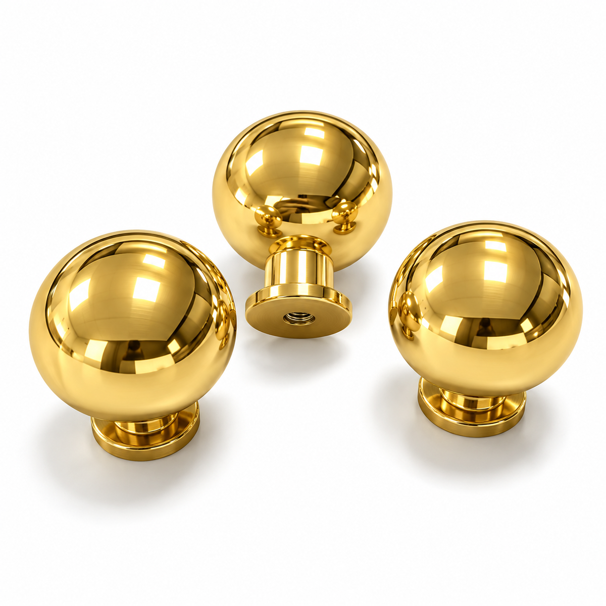 Three solid unlacquered brass ball cabinet knobs on white, showing polished heads, stepped bases and a threaded fixing hole