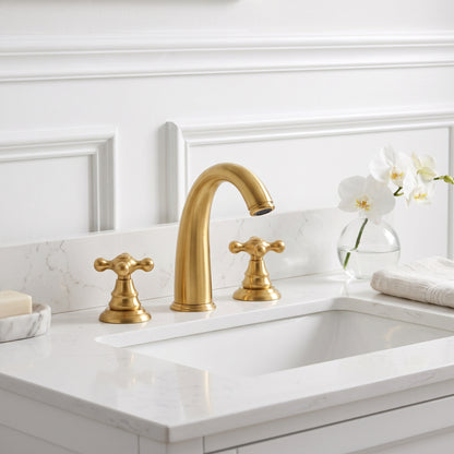 Unlacquered brass widespread faucet above a rectangular basin on a white vanity with paneled walls and orchids