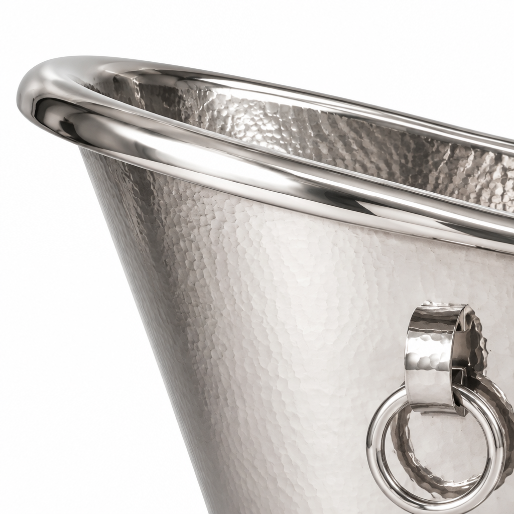 Close-up of a hammered silver metal bucket with a polished rim and a hanging ring handle on a white background.